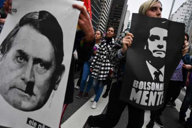 Protesters hold up placards comparing Jair Bolsonaro to Adolf Hitler, in Sao Paulo, Brazil, in 2018.