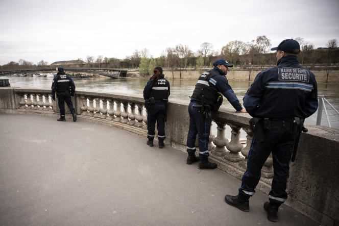 Security agents from the city of Paris patrol the quays of the Seine in March 2020.