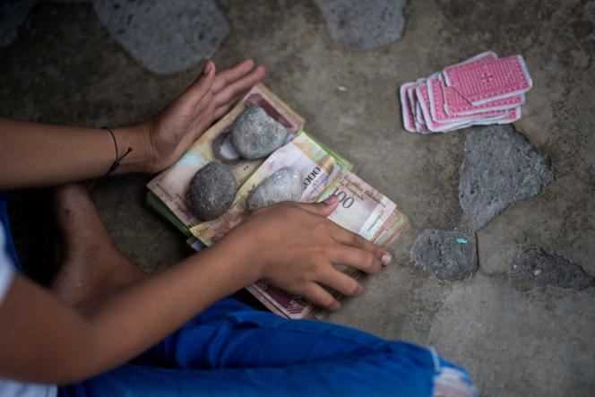 Children play cards and bet with unused Venezuelan bolivar banknotes in the city of Puerto Concha, Venezuela on September 9, 2021.