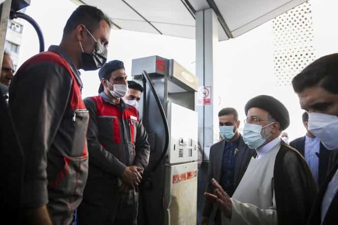 Iranian President Ebrahim Raïssi (center) speaks with gas station attendants on October 27, 2021, in Tehran, the day after the cyberattack that paralyzed gas stations across the country.