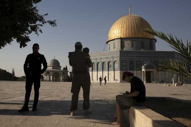 An Israeli policeman stands guard as a religious Jew in uniform visits the Temple Mount inside the compound of Al-Aqsa Mosque in Jerusalem on August 3, 2021.