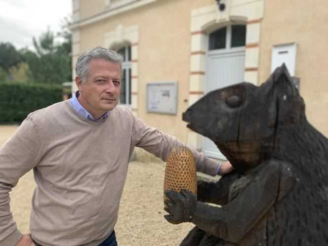 Jean-Christophe Rouxel, mayor of La Lande-Chasles (Maine-et-Loire), in front of a squirrel - the emblem of the town - carved from two oak trunks.
