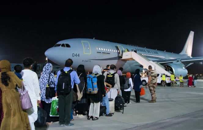Afghan refugees board a French Air Force Airbus during a stopover in the United Arab Emirates on August 23.