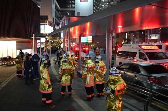 Firefighters gather around Kokuryo station where the train was immobilized following a knife attack and the start of a fire, in Tokyo on October 31, 2021.
