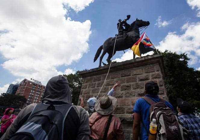 Protesters attempt to topple a statue of Christopher Columbus in Guatemala City on Tuesday, October 12.