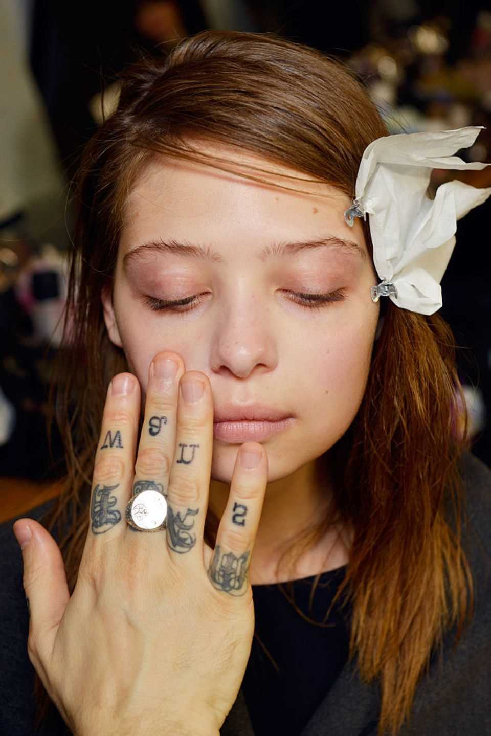 Make-up is applied to a model with the fingers, backstage