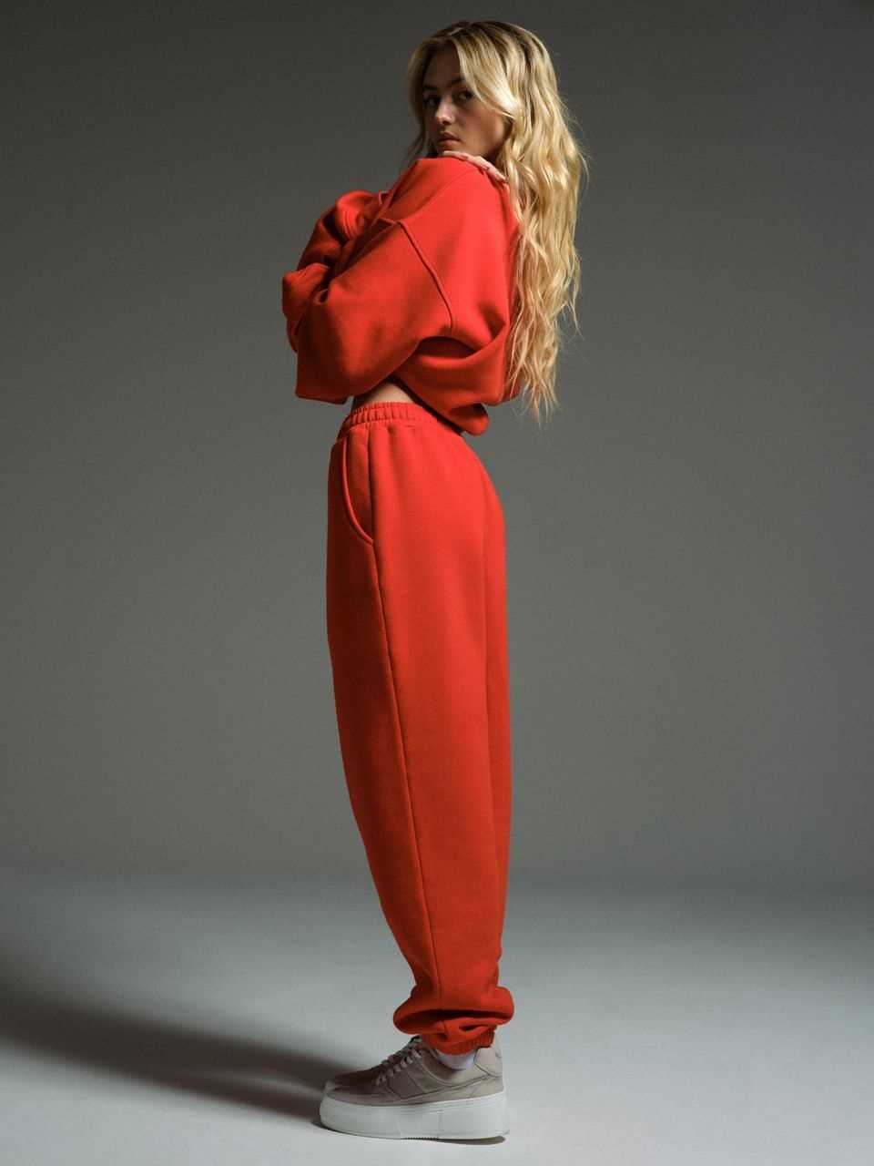 Leni Klum poses for a photo in a red jogging suit.
