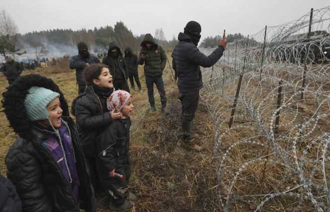 Migrants face barbed wire at the Belarus-Poland border on November 17, 2021.