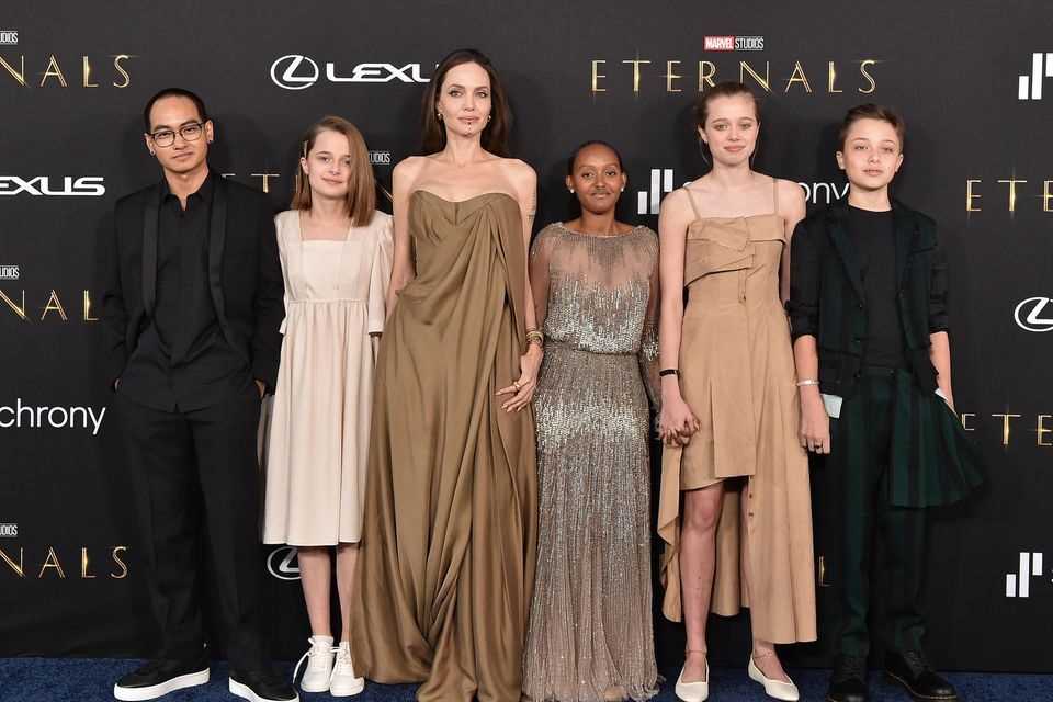 Angelina Jolie with her children Maddox, Vivienne, Zahara, Shiloh and Knox Jolie-Pitt at the Los Angeles premiere of "Eternals" on October 18, 2021. Zahara shone in a silver floor-length gown that appeared to be the same Elie Saab Couture dress that Jolie wore to the 2014 Academy Awards.  And in other ways too, mother and children have matched their colors to one another.  A rare red carpet appearance. 