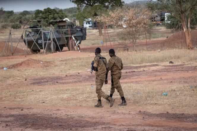 Burkinabe officers pass near one of the vehicles of the French military convoy, in Kaya, on November 20, 2021.