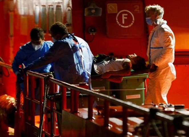 Rescuers disembark a migrant from a Spanish coastguard boat in Arguineguin, on the island of Gran Canaria, on November 14, 2021.