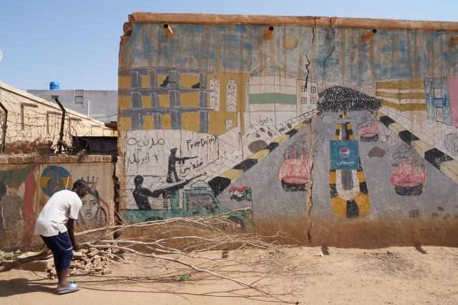 A man in front of a fresco painted in homage to the revolution of April 6, 2019 in one of the revolutionary districts of Omdurman, November 7, 2021.
