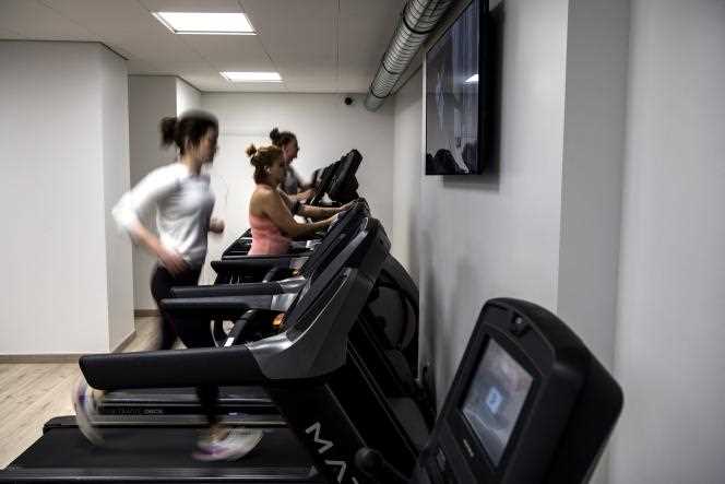 People run on treadmills in a fitness center in Paris, February 3, 2020.