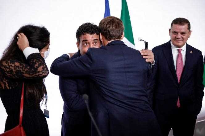 French President Emmanuel Macron hugs the President of the Libyan Presidential Council, Mohammed Al-Menfi, under the gaze of the head of the government of national unity, Abdel Hamid Dbeibah, on November 12, 2021 on the sidelines of the international conference on Libya in Paris.