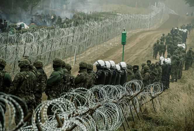 Polish soldiers and police monitor migrants at the Belarusian border on November 12, 2021.