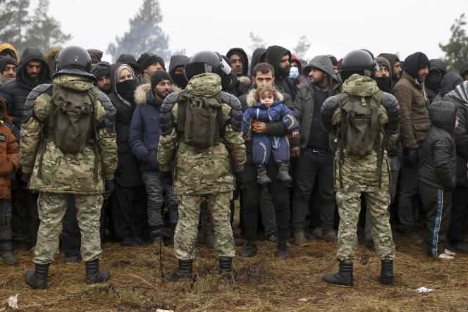 Hundreds of migrants face Belarusian soldiers on the border with Poland on November 14, 2021.