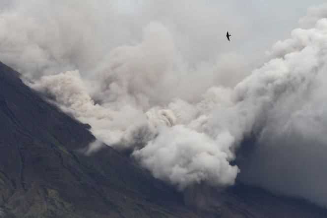 The highest peak of the island of Java threw a vast plume of ash on Saturday and caused waves of burning mud which invaded villages located on its sides and left 15 dead.