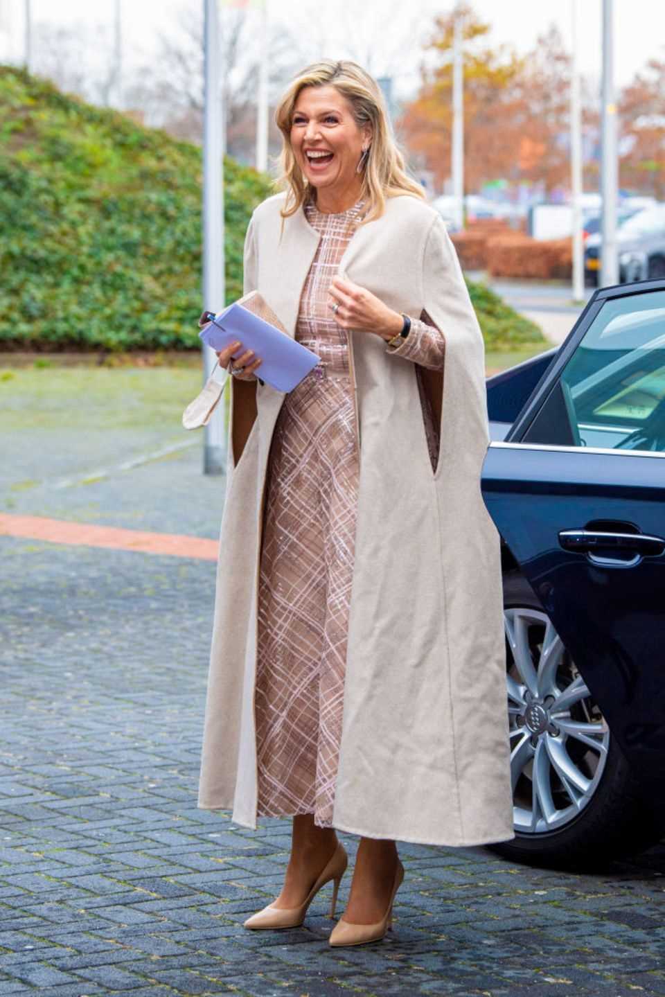 Queen Máxima is visibly happy and shines so beautifully that the folds on her cape are hardly noticeable.