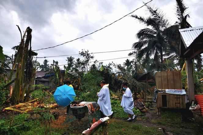 In this photo taken on December 24, 2021, Father Ricardo Virtudazo visits parishioners affected by the typhoon in Alegria, in the province of Surigao del Norte.