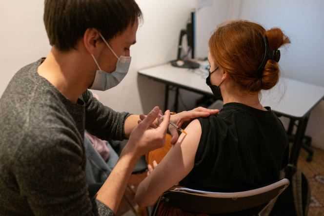 A young woman receives a dose of vaccine against Covid-19 at a vaccination center in the 10th arrondissement in Paris, on December 2, 2021.