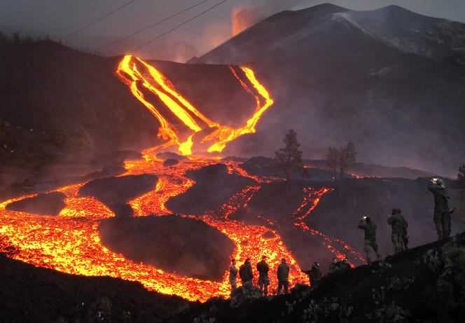 Spanish soldiers stand on a hill and watch lava flow on the Canary Island of La Palma, Spain, November 29, 2021.