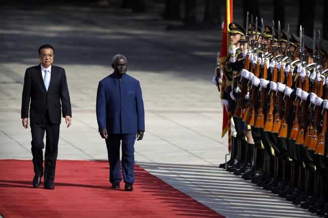 Chinese Premier Li Keqiang, left, greets Solomon Islands Premier Manasseh Sogavare and walks through an honor guard in Beijing, Wednesday, October 9, 2019.