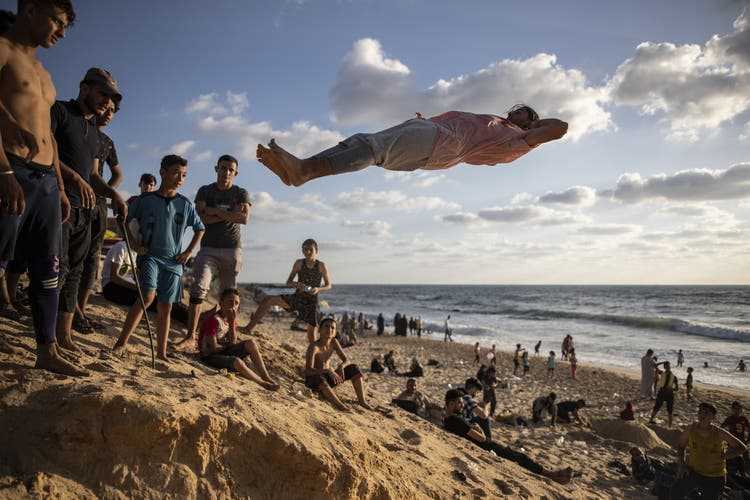 Young Palestinians watch an acrobat. 