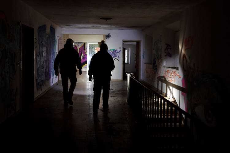 It's dark inside the clinic - the Urban Explorers are walking through the spray-covered corridors with flashlights.