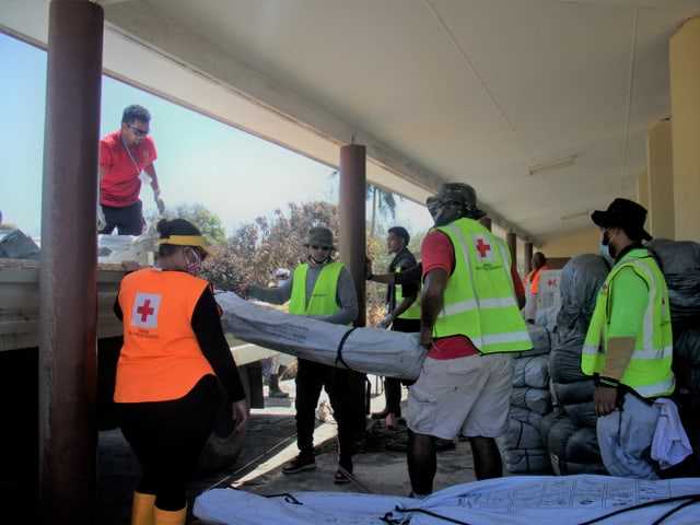 Red Cross workers load relief supplies.