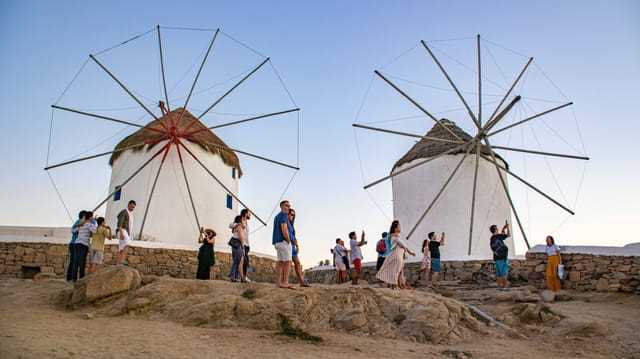Touristen fotografieren Windmühlen auf Mykonos.
