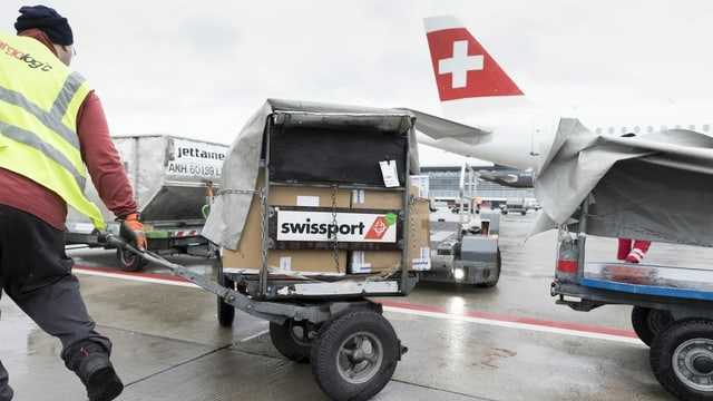 Ein Swissport-Mitarbeiter verlädt Gepäck.
