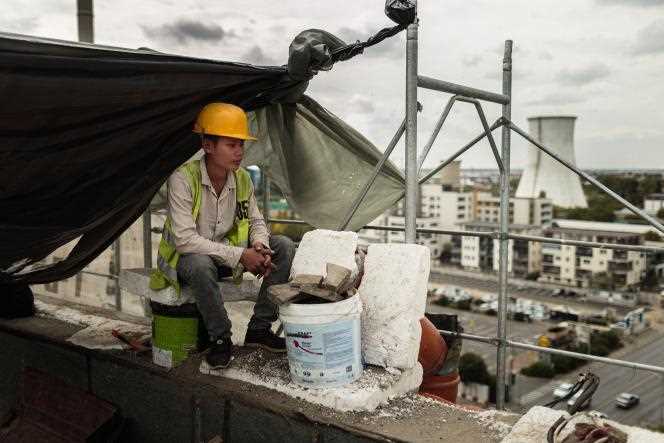A Vietnamese man pauses on the roof of a building under construction in Bucharest on September 26, 2019.