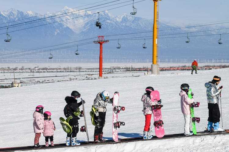 Children, fully equipped, on the magic carpet at the Baiyun Ski Resort.