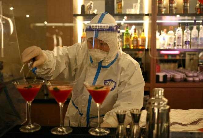 A bartender dressed in personal protective equipment prepares cocktails at a hotel in Zhangjiakou on Friday (February 4).