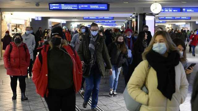 Personen mit Maske im Bahnhof Bern.