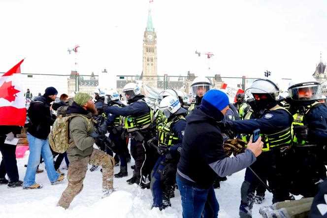 Police try to dislodge protesters blocking the main street in front of the Canadian Parliament, in Ottawa, February 19, 2022.