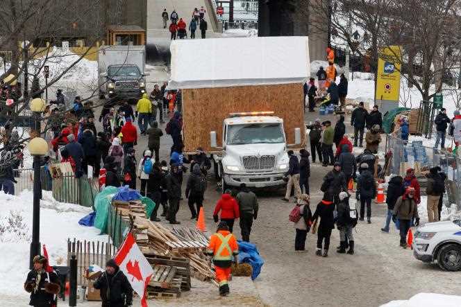 Truckers protesting health restrictions carry away a shack that was used to serve the soup kitchen, in Ottawa, February 6, 2022.