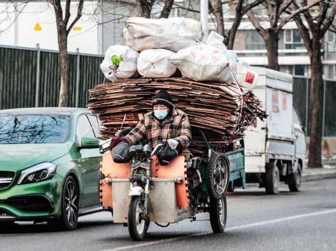 A migrant worker carrying recyclable cardboard in Beijing on January 20, 2022.