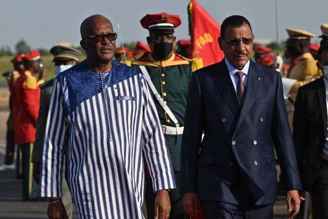 Former Burkina Faso President Roch Marc Christian Kaboré (left) greets Nigerien Head of State Mohamed Bazoum upon his arrival at Ouagadougou airport on October 17, 2021.