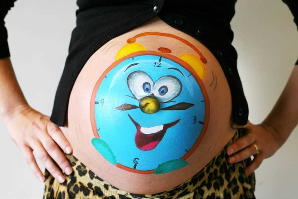 Paint baby bump: Funny clock painted on baby bump