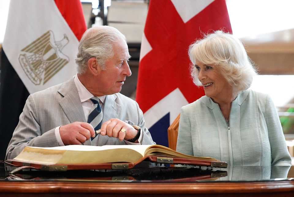 Prince Charles and Duchess Camilla sign a guest book in Alexandria