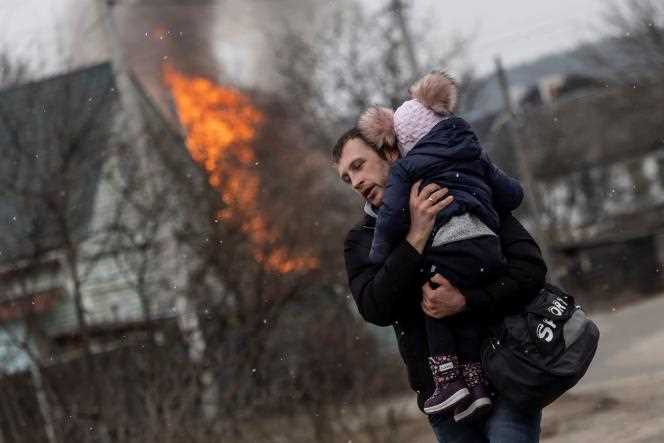 A man and a child escape from the town of Irpin, after heavy shelling of the only escape route used by residents, as Russian troops advance towards the capital of Kiev, in Irpin, near Kiev, in Ukraine, March 6, 2022.