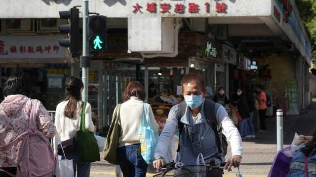 Menschen tragen draussen in Hongkong Schutzmasken.