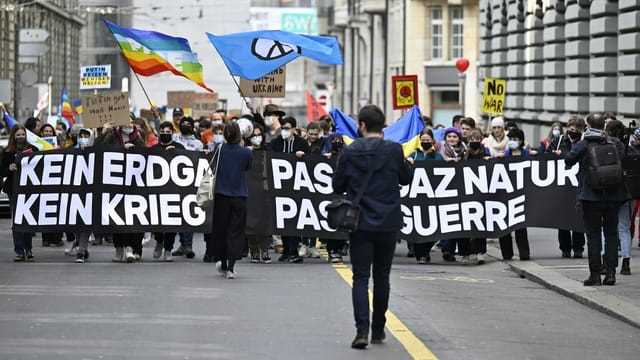 Demonstrierende tragen in Bern ein langes Transparent gegen den Krieg in der Ukraine.