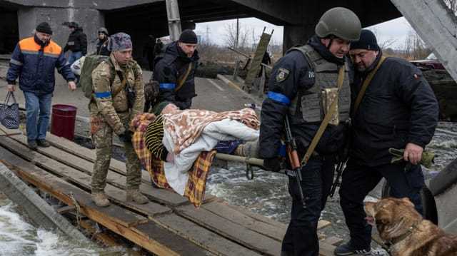 Ukrainische Soldaten tragen eine ältere Person während einer Evakuierung in Irpin ausserhalb von Kiew, aufgenommen am 13. März 2022.