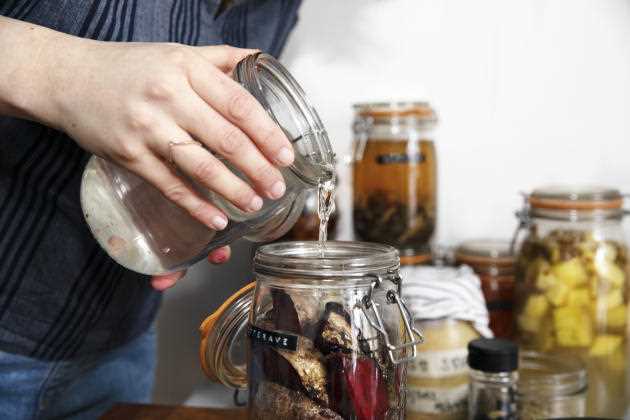 Malika Nguon fills the jar filled with pieces of ginger with brine;  All that remains is to close the jar hermetically and wait a fortnight.