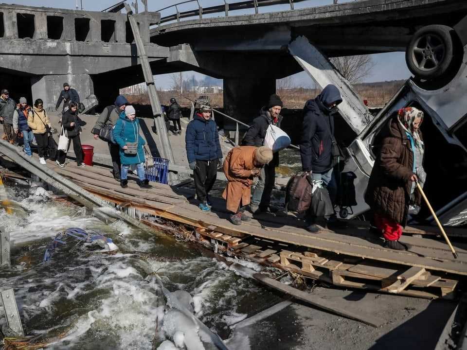 Refugees cross the Irpin River outside of Kyiv.