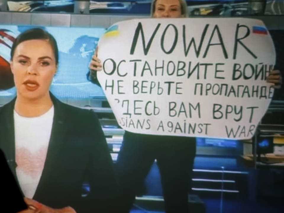 TV employee Marina Ovsiannikova holds a poster in front of the camera during the news broadcast on the state broadcaster.