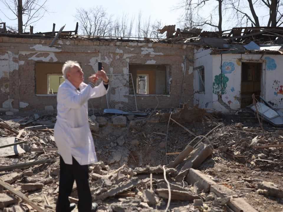Doctor Anatoly Pavlov photographs a damaged psychiatric hospital in Mykolayiv.