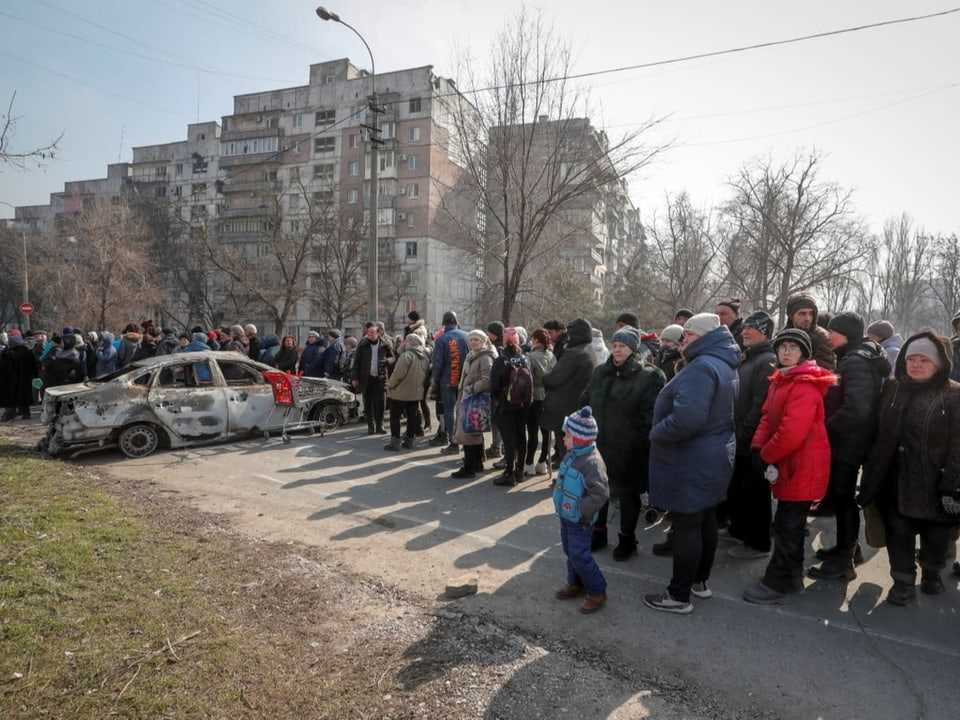 People in Mariupol queue for humanitarian supplies.
